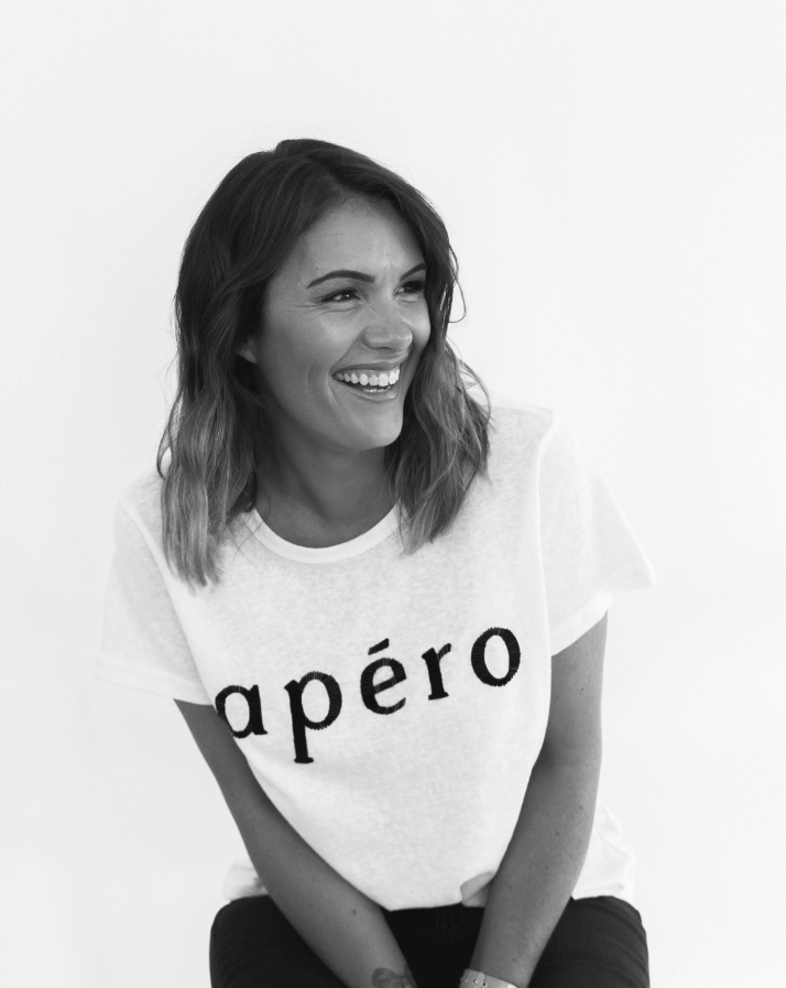 laughing woman wearing a white shirt that reads apero